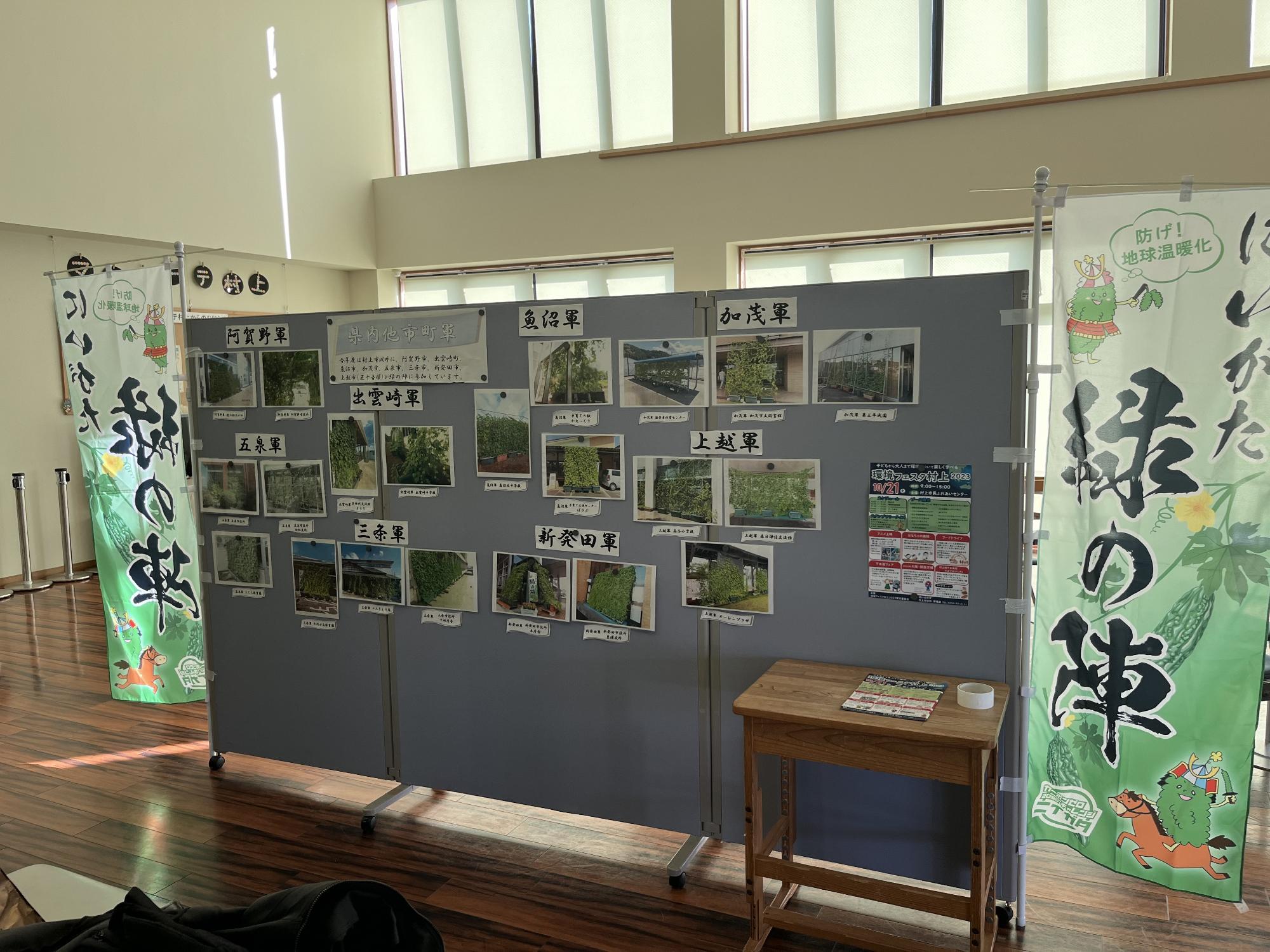 環境フェスタ村上2023のパネル展ブースに各市町村のグリーンカーテンの写真が掲示されている様子