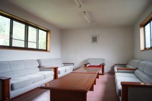 3人掛けのソファーが4つ向かい合わせに置かれてあり、間に2台のテーブルがあるミーティングルームの写真
