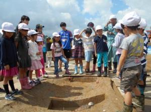 村北遺跡の発掘調査現場を見学している新潟大学附属新潟小学校1・2年生の写真