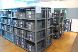 グレーのケースが棚にきれいに並べられている埋蔵文化財収蔵庫の写真