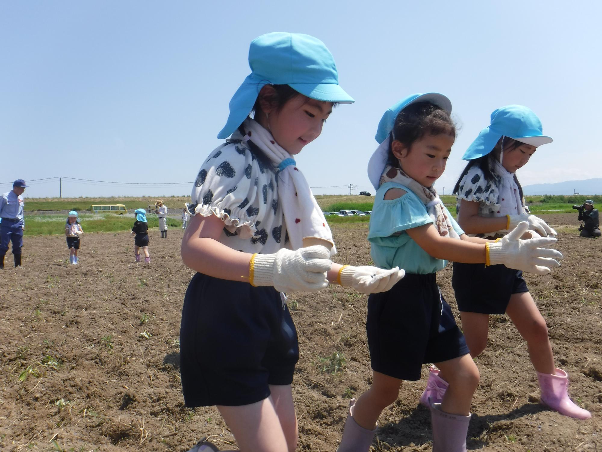 子ども達がきれいな花を咲くようにお願いしながら種まきをしている様子
