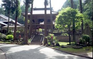 背の高い木や植え込みの奥に立派な門がある観音寺の写真