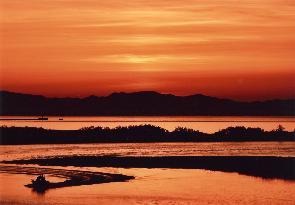 夕焼けの空と赤く染まる川を写した写真