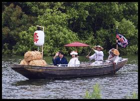 舟に乗った花嫁と花婿が微笑む写真