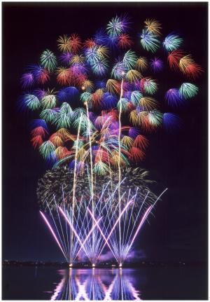 大空に打ち上げられた赤、青、黄色、水色、緑、紫などの色とりどりの花火の写真