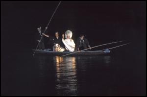着物を着た男性、綿帽子に白無垢の女性、2人の船頭が船に乗っている写真