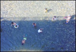 透き通ったきれいな水の川で遊んでいる子供たちを真上から撮影した写真