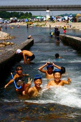 水中眼鏡やシュノーケルをつけて川遊びをしている子供たちの写真