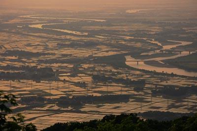 くねくねと蛇行している阿賀野川と周辺の田んぼや畑を撮影したセピアカラーの写真