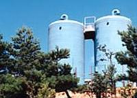 青い大きな2基のpH調整塔の写真