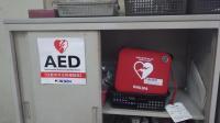 AEDと書かれた紙が貼られた棚の引き戸が開いた中に設置されているAEDの写真