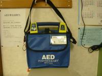 AEDと書かれた青色バックが壁にかけられている写真