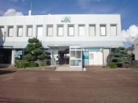 白い壁の建物に「JA]のマークがあり、たくさんの窓がある2階建ての北蒲みなみ農業協同組合 安田支店外観写真