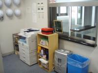 阿賀北葬斎場の事務室のコピー機の隣にAEDが設置されている写真