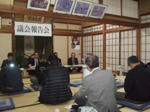 中潟担い手センターで座りながら議会報告会を行っている男性たちの写真